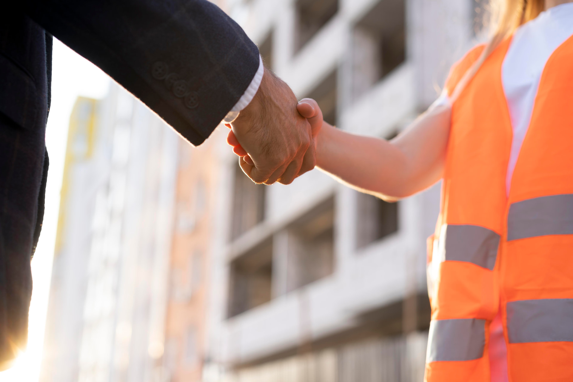 Handshake between a company representative and a construction professional on a building site in Belgium
